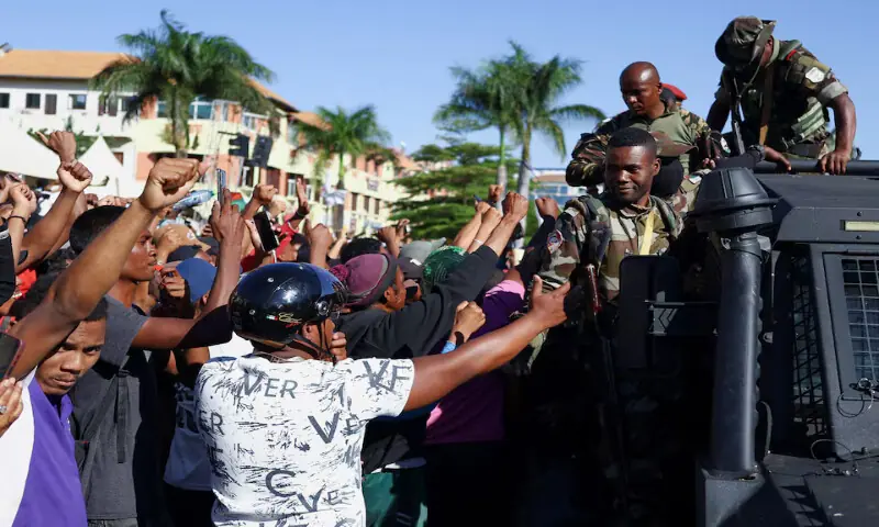 Locals react as members of the Madagascar military arrive to join protesters gathered outside the town hall in Antananarivo, Madagascar, on Tuesday. – Reuters