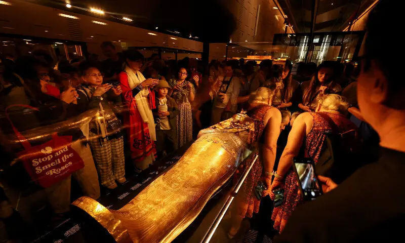 Visitors look at the golden coffin of Pharaoh Tutankhamun. – Reuters