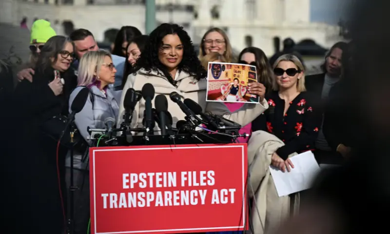 Survivor Lisa Phillips holds up her picture as she speaks during a press conference on the Epstein Files Transparency Act ahead of a House vote on the release of files related to the late convicted sex offender Jeffrey Epstein, on Capitol Hill in Washington, DC, on November 18, 2025. Reuters