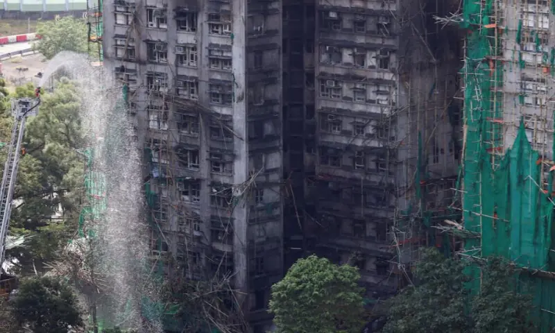 A firefighter works in front of the multiple charred buildings of Wang Fuk Court complex following a deadly fire, in Tai Po, Hong Kong, on November 28, 2025. Reuters