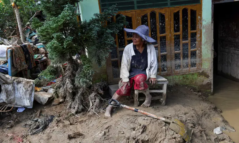 Survivor Rismawati Simanjuntak sits as she takes a break while collecting valuable goods and cleaning her house following deadly flash flood in Batang Toru, South Tapanuli, North Sumatra province, Indonesia, on Saturday. – Reuters
