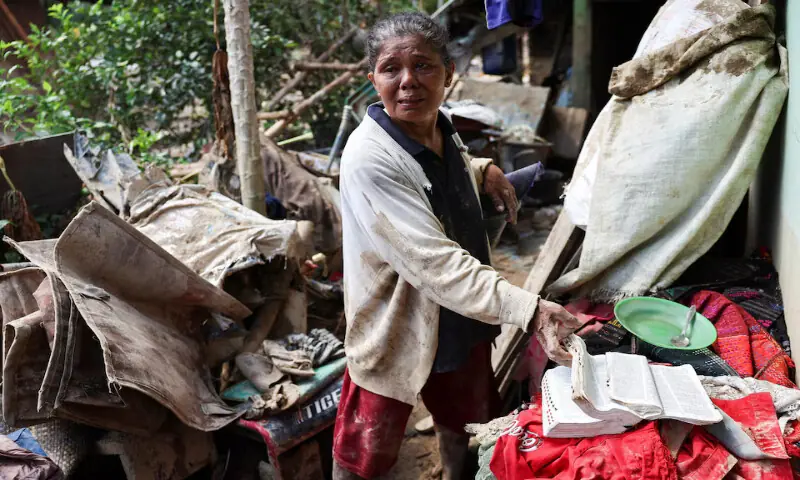Survivor Rismawati Simanjuntak reacts while collecting her belongings recovered from her house following deadly flash flood in Batang Toru, South Tapanuli, North Sumatra province, Indonesia, December 6, 2025. REUTERS/Willy Kurniawan Purchase Licensing Rights, opens new tab