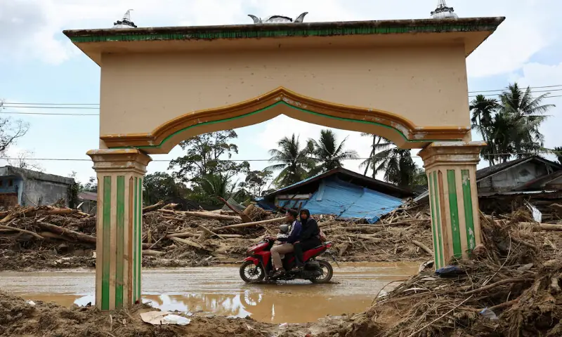 Local residents ride a motorbike at an area following deadly flash flood in Batang Toru, South Tapanuli, North Sumatra province, Indonesia. – Reuters