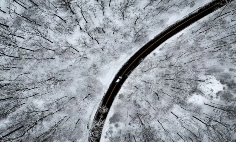A drone view of a car driving through the snow-covered woods of Blauvelt State Park after a winter storm bore down on the U.S. Northeast in Orangetown, New York, U.S., on December 27, 2025. Reuters