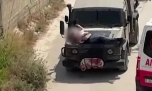 Israeli forces strap wounded Palestinian to jeep during raid