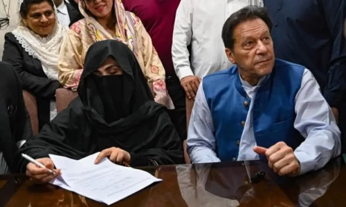 Former prime minister, Imran Khan (R) along with his wife Bushra Bibi (L) looks on as he signs surety bonds for bail in various cases, at a registrar office in the High court, in Lahore on July 17, 2023. AFP