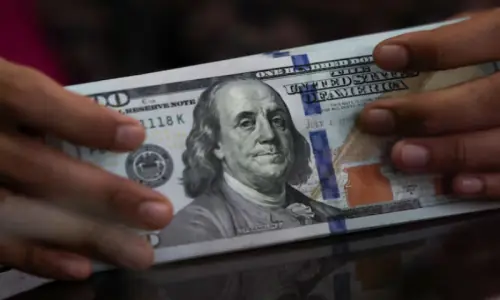 Dollar holds gains in thin trading as markets await Fed minutes, US GDP