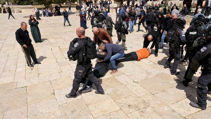 Two people lie on the ground during clashes between Israeli security forces and Palestinians at the Al-Aqsa mosque compound. AFP photo