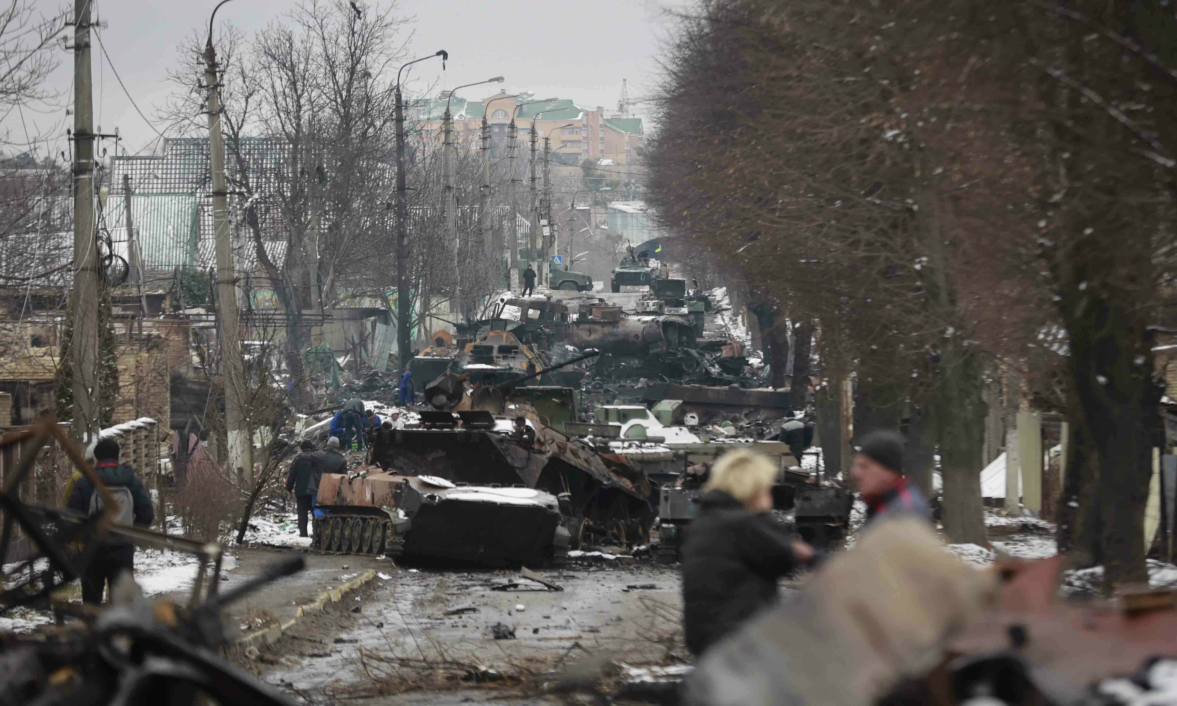 People look at the gutted remains of Russian military vehicles on a road in the town of Bucha, close to the capital Kyiv on Tuesday. AP file photo