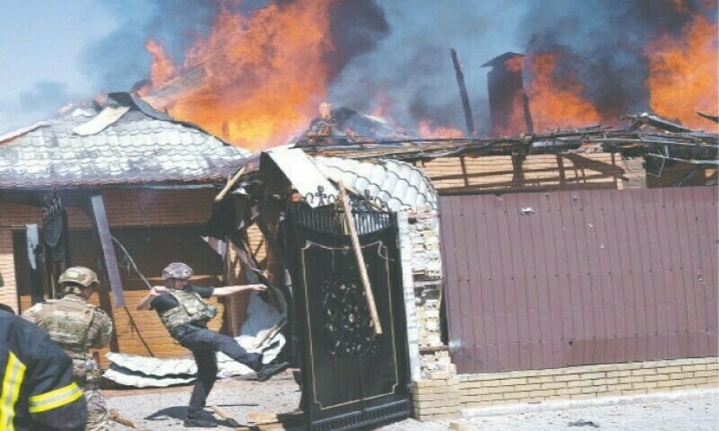 Ukrainian soldiers and firefighters arrive at a burning house hit by a shell on the outskirts of Bakhmut, a town in southern Ukraine. Photo: AFP.