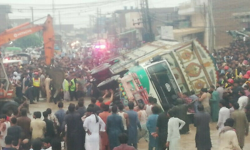 People trying to rescue passengers trapped in the passenger vechile crushed under