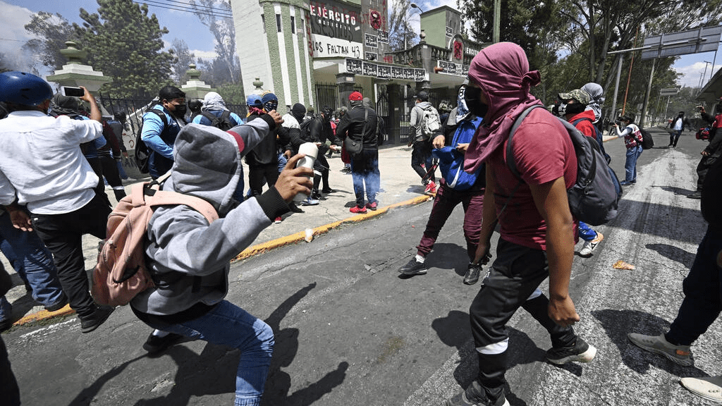 Protesters throw stones and homemade explosive devices at a Mexican military camp during a demonstration over the disappearance of 43 students in 2014. AFP Protesters throw stones and homemade explosive devices at a Mexican military camp during a demonstration over the disappearance of 43 students in 2014. AFP