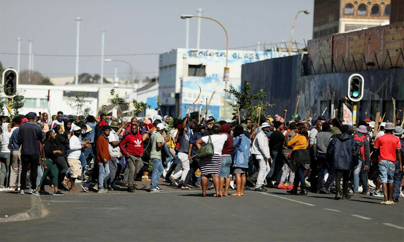 Stick-wielding protesters march through the streets as violence following the jailing of former South African President Jacob Zuma spread to the country&rsquo;s main economic hub in Johannesburg, South Africa, July 11, 2021. Reuters