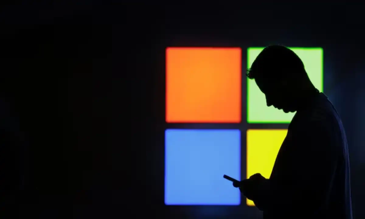 A man looks at his phone as he passes by the Microsoft stand at the Mobile World Congress trade show in Barcelona on March 3, 2025. Reuters file