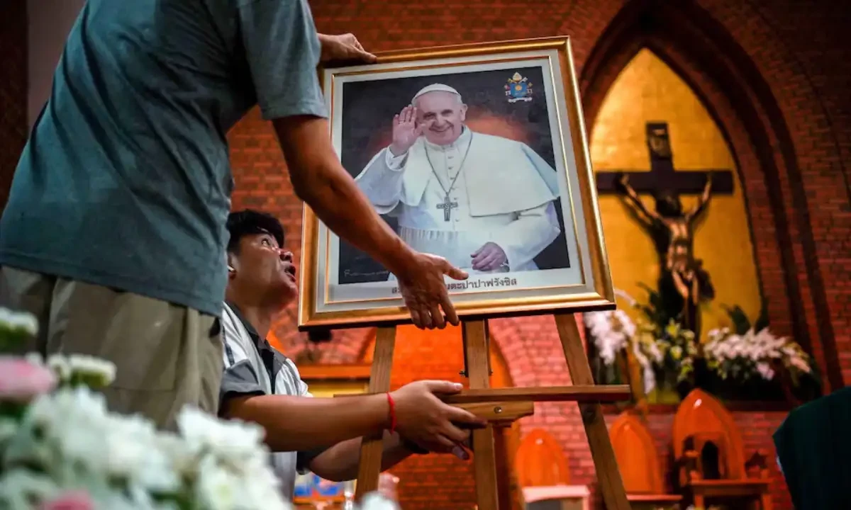 Workers hold up a picture of Pope Francis before a Mass, after his death was announced by the Vatican, at Saint Louis Catholic Church in Bangkok, Thailand, April 21, 2025. REUTERS Workers hold up a picture of Pope Francis before a Mass, after his death was announced by the Vatican, at Saint Louis Catholic Church in Bangkok, Thailand, April 21, 2025. REUTERS