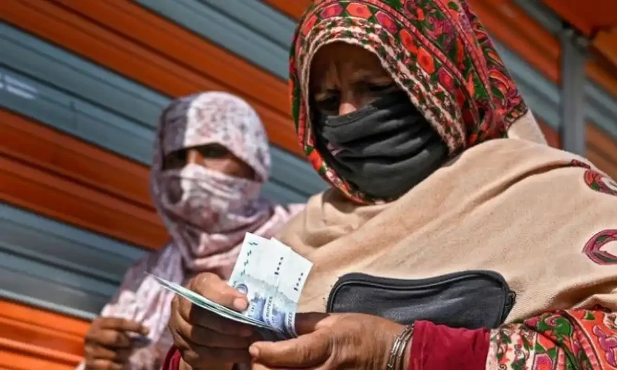 In this file photo, a woman in a face mask counts rupee notes as she walks on a street in Islamabad on April 9, 2020. AFP In this file photo, a woman in a face mask counts rupee notes as she walks on a street in Islamabad on April 9, 2020. AFP