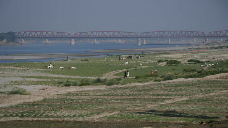 People walk next to a cultivated land on the dry riverbed of the Indus River in Hyderabad, Pakistan. – Reuters file