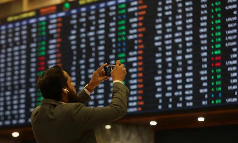 A man uses a mobile phone as he takes a photo of the electronic board displaying share prices during a trading session at the Pakistan Stock Exchange, in Karachi, Pakistan November 28, 2023. REUTERS A man uses a mobile phone as he takes a photo of the electronic board displaying share prices during a trading session at the Pakistan Stock Exchange, in Karachi, Pakistan November 28, 2023. REUTERS