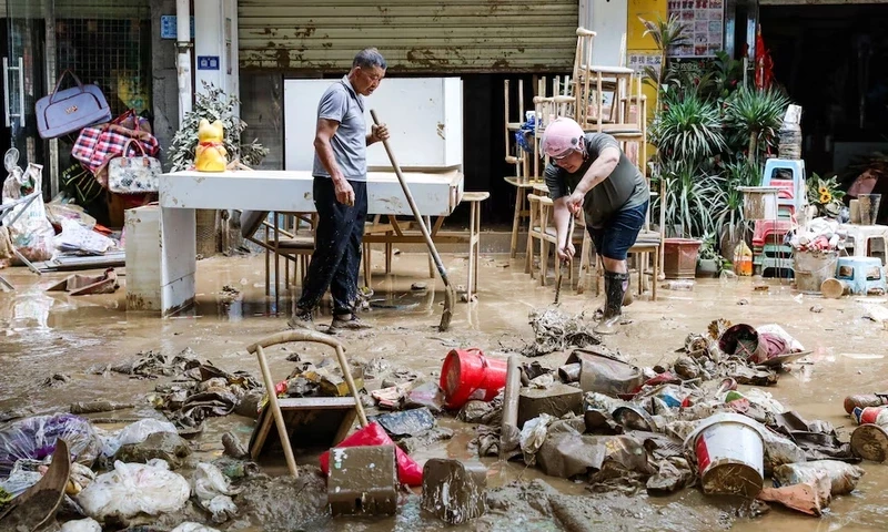 Residents clean up debris on a street after floodwaters receded in Rongjiang county, Guizhou province, China June 25. cnsphoto via REUTERS Residents clean up debris on a street after floodwaters receded in Rongjiang county, Guizhou province, China June 25. cnsphoto via REUTERS