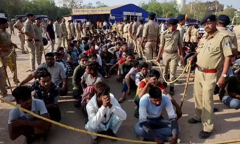 Police officers stand next to men they believe to be undocumented Bangladeshi nationals after they were detained during raids in Ahmedabad, India, April 26, 2025.Reuters