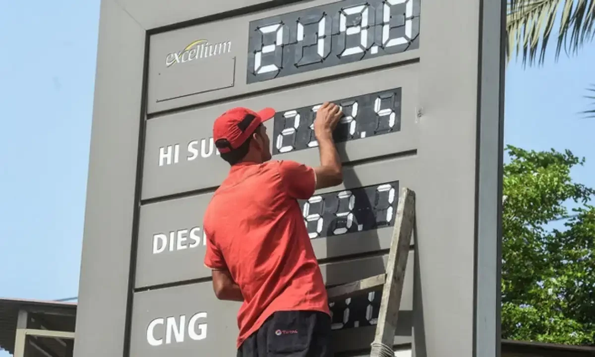 An employee of a petrol station updates the latests fuel prices on a board in Karachi on June 16, 2022, after a hike in prices of petroleum products by the government. AFP