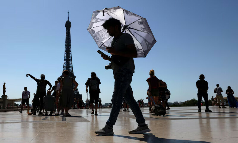 A tourist holding an umbrella to protect himself from the sun walks at Trocadero square next to the Eiffel Tower as an early summer heatwave hits Paris, France. – Reuters A tourist holding an umbrella to protect himself from the sun walks at Trocadero square next to the Eiffel Tower as an early summer heatwave hits Paris, France. – Reuters