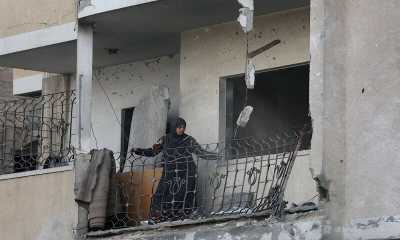A Palestinian woman looks at the damage at the site of an Israeli strike on a house, in Zawayda in the central Gaza Strip on Tuesday. – Reuters A Palestinian woman looks at the damage at the site of an Israeli strike on a house, in Zawayda in the central Gaza Strip on Tuesday. – Reuters