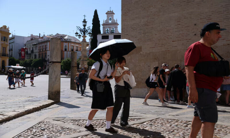 People walk during a heatwave, in Seville, Spain, on Wednesday. – Reuters People walk during a heatwave, in Seville, Spain, on Wednesday. – Reuters