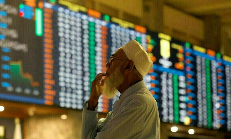 A stock broker reacts while monitoring the market on the electronic board displaying share prices during a trading session at the Pakistan Stock Exchange, in Karachi, Pakistan July 3, 2023. Reuters