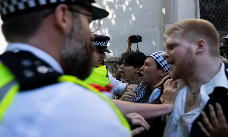 Supporters of the Palestine Action group scuffle with police officers outside the High Court in London. – Reuters