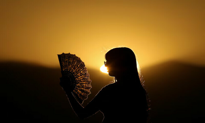 A girl cools off from the heat with a paper fan in Skopje, North Macedonia. – Reuters A girl cools off from the heat with a paper fan in Skopje, North Macedonia. – Reuters