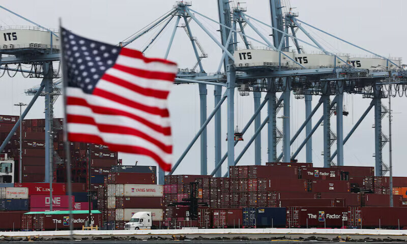 A US flag flutters in front of shipping containers at the Port of Long Beach in Long Beach, California, U.S. – Reuters