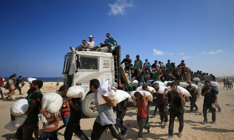 Palestinians carry aid supplies in Beit Lahia in the northern Gaza Strip on Sunday. – Reuters Palestinians carry aid supplies in Beit Lahia in the northern Gaza Strip on Sunday. – Reuters