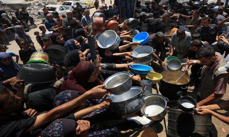 Palestinians gather to receive food from a charity kitchen in Gaza City. – Reuters Palestinians gather to receive food from a charity kitchen in Gaza City. – Reuters