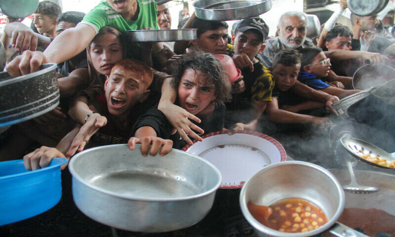 Palestinians gather to receive food cooked by a charity kitchen in the northern Gaza Strip. – Reuters Palestinians gather to receive food cooked by a charity kitchen in the northern Gaza Strip. – Reuters