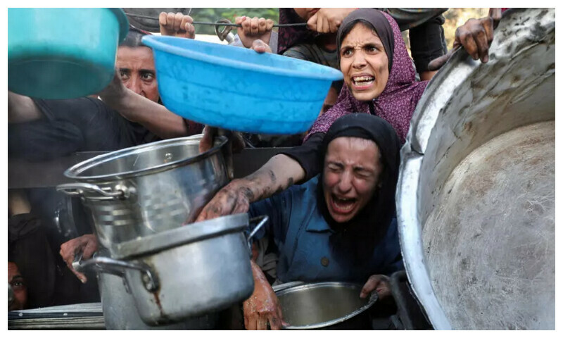 File photo: Palestinians react as they ask for food from a charity kitchen, amid a hunger crisis, in Gaza City, July 14, 2025. © Reuters