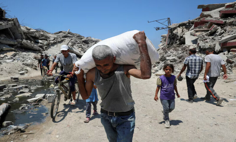 A Palestinian carries a bag with aid supplies in Beit Lahia, northern Gaza Strip, on Sunday. – Reuters