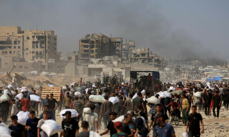 Palestinians carry aid supplies that entered Gaza in Beit Lahia in the northern Gaza Strip on Sunday. – Reuters