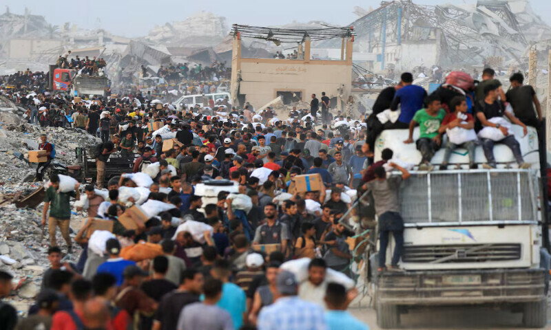 Palestinians carry aid supplies in Beit Lahia, in the northern Gaza Strip. – Reuters