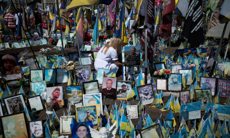 A woman pays tribute at a memorial to fallen soldiers on Independence Square in Kyiv, Ukraine. – Reuters