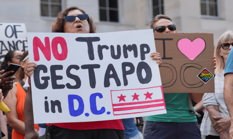 A demonstrator holds a sign during a protest near the White House, as US President Donald Trump announced he is placing the DC Metropolitan Police Department under direct federal control and deploying National Guard troops to Washington, DC, in Washington DC, on August 11, 2025. Reuters A demonstrator holds a sign during a protest near the White House, as US President Donald Trump announced he is placing the DC Metropolitan Police Department under direct federal control and deploying National Guard troops to Washington, DC, in Washington DC, on August 11, 2025. Reuters
