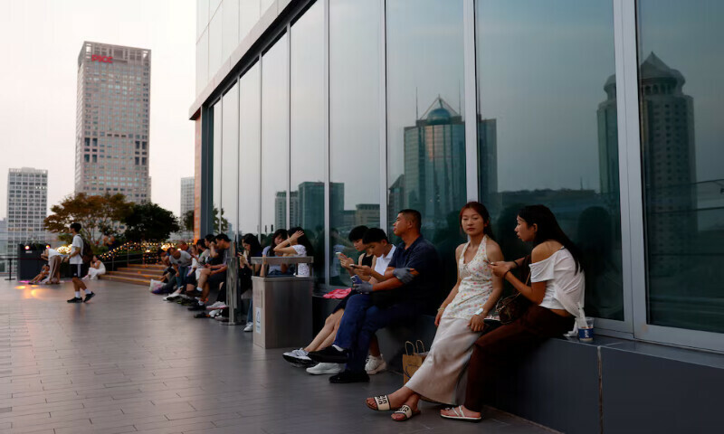 People rest on a terrace of a shopping mall during sunset hour in Beijing’s central business district. – Reuters People rest on a terrace of a shopping mall during sunset hour in Beijing’s central business district. – Reuters