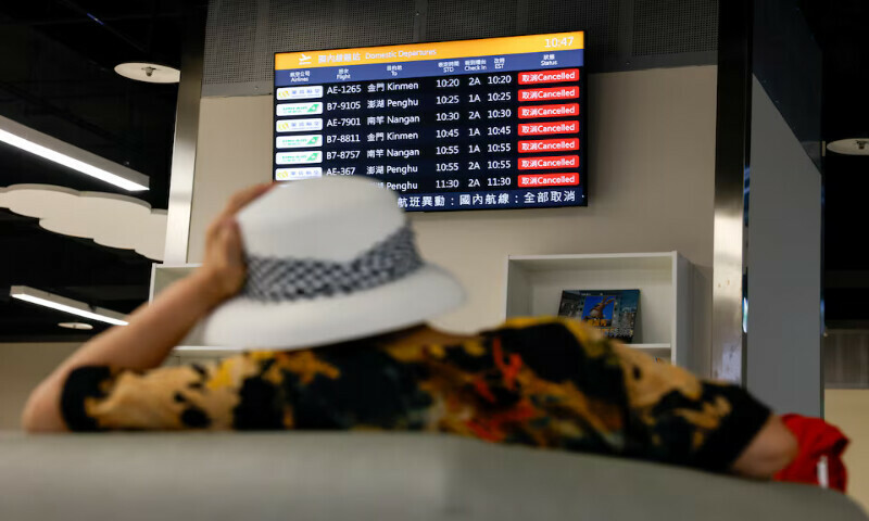 A woman sits in front of a screen displaying information on cancelled domestic flights as Typhoon Podul approaches the country in Taipei, Taiwan, on Wednesday. – Reuters A woman sits in front of a screen displaying information on cancelled domestic flights as Typhoon Podul approaches the country in Taipei, Taiwan, on Wednesday. – Reuters