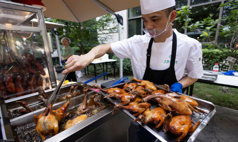 A chef fries food at a food stall near Beiyuan Grand Hotel in Beijing, China. – Reuters A chef fries food at a food stall near Beiyuan Grand Hotel in Beijing, China. – Reuters