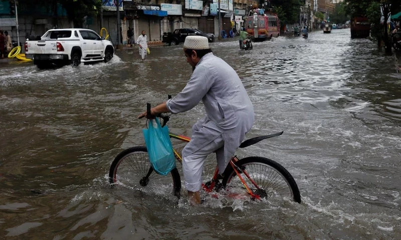 A man rides bicycle along a flooded road, following heavy rains during the monsoon season in Karachi, Pakistan July 25, 2022. REUTERS