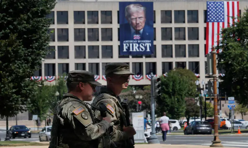Members of the National Guard patrol the National Mall past a banner of US President Donald Trump hanging on the Department of Labour building in Washington, DC. – Reuters Members of the National Guard patrol the National Mall past a banner of US President Donald Trump hanging on the Department of Labour building in Washington, DC. – Reuters