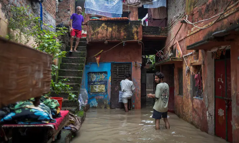 People stand outside their flooded houses after a rise in the water level of river Yamuna in New Delhi, India. – Reuters People stand outside their flooded houses after a rise in the water level of river Yamuna in New Delhi, India. – Reuters