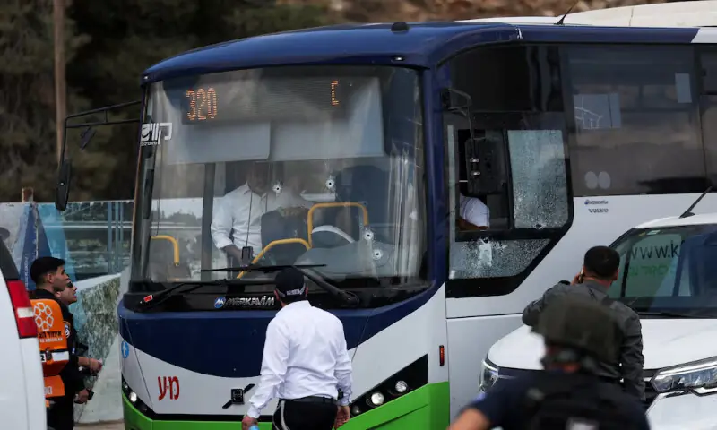 People inspect a bus with bullet holes in the windshield at the scene where a suspected shooting attack took place on the outskirts of Jerusalem on Monday. – Reuters People inspect a bus with bullet holes in the windshield at the scene where a suspected shooting attack took place on the outskirts of Jerusalem on Monday. – Reuters