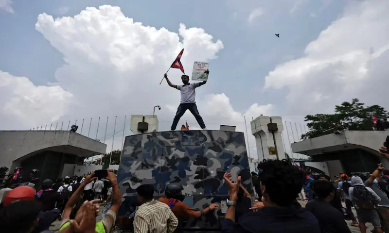 A demonstrator waves a flag as he stands atop a vehicle near the entrance of the Parliament during a protest against corruption and government’s decision to block several social media platforms in Kathmandu, Nepal, on Monday. – Reuters A demonstrator waves a flag as he stands atop a vehicle near the entrance of the Parliament during a protest against corruption and government’s decision to block several social media platforms in Kathmandu, Nepal, on Monday. – Reuters