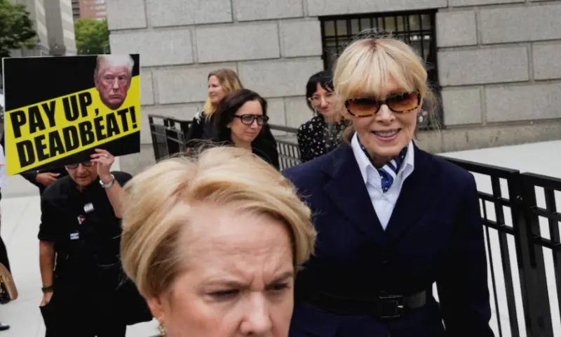 A demonstrator holds up a sign behind writer E. Jean Carroll as she leaves the 2nd US Circuit Court of Appeals, where former US President Donald Trump is asking a federal appeals court to overturn a $5 million jury verdict finding him liable for sexually assaulting and defaming her, who accused Trump of raping her nearly three decades ago, in Manhattan, New York, on September 6, 2024. Reuters file A demonstrator holds up a sign behind writer E. Jean Carroll as she leaves the 2nd US Circuit Court of Appeals, where former US President Donald Trump is asking a federal appeals court to overturn a $5 million jury verdict finding him liable for sexually assaulting and defaming her, who accused Trump of raping her nearly three decades ago, in Manhattan, New York, on September 6, 2024. Reuters file
